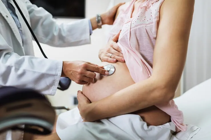 Ilustración de referencia: revisión médica del embarazo con estetoscopio