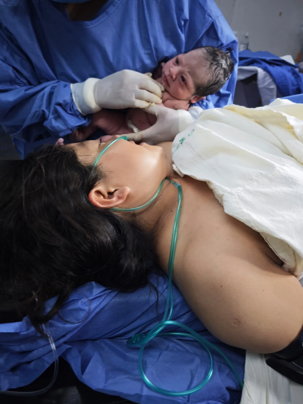 Contacto piel con piel entre madre y recién nacido tras el parto, con apoyo de oxígeno